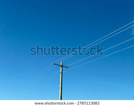 Electrical utility infrastructure and power distribution lines against clear blue sky showing public energy network and outdoor utility systems