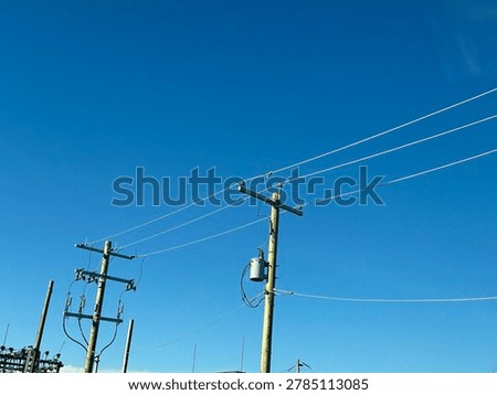 Electrical utility infrastructure and power distribution lines against clear blue sky showing public energy network and outdoor utility systems