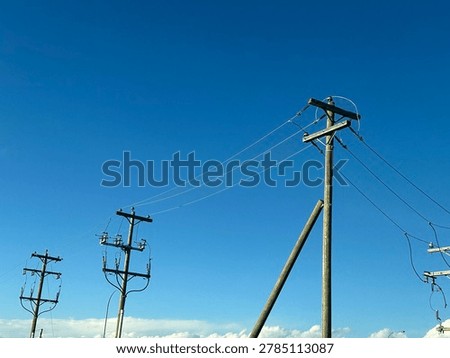 Electrical utility infrastructure and power distribution lines against clear blue sky showing public energy network and outdoor utility systems