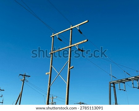 Electrical utility infrastructure and power distribution lines against clear blue sky showing public energy network and outdoor utility systems