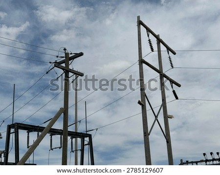 Electrical utility pole and overhead power lines against cloudy sky showing public infrastructure and energy distribution network