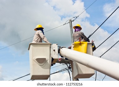 Electrical Utility Worker In A Bucket Fixes A Problem With A Power Line.