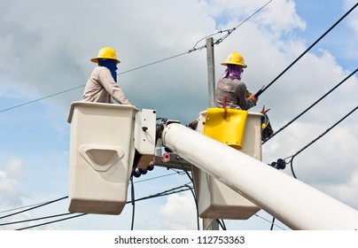 An Electrical Utility Worker In A Bucket Fixes A Problem With A Power Line.