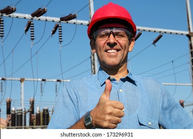 Electrical Utility Worker. Electricity Distribution. Thumb Up Given By Smiling Engineer Next To Electrical Substation. 