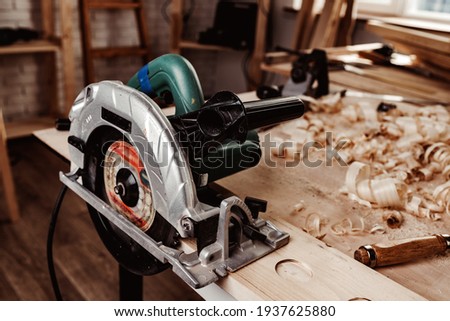 Electrical wheel saw on working table in carpentry workshop