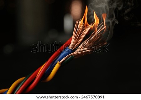 Electrical wire burning on dark background, closeup