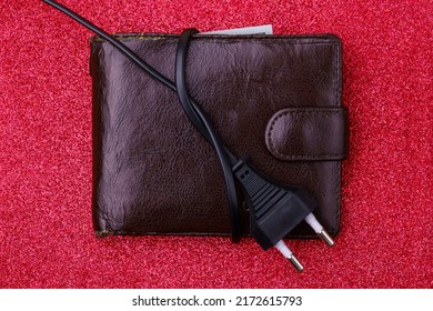 An electrical wire tied into a knot on an old decrepit wallet. The concept of the energy crisis and electricity inflation. Rising electricity prices. Copy space.