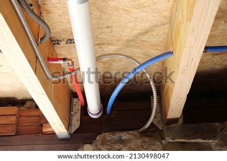 Electrical Wires, PEX and PVC Piping in a Wooden Floor Joist