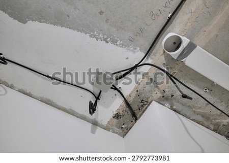 Electrical wiring connected to a junction box mounted on a concrete ceiling during construction or renovation