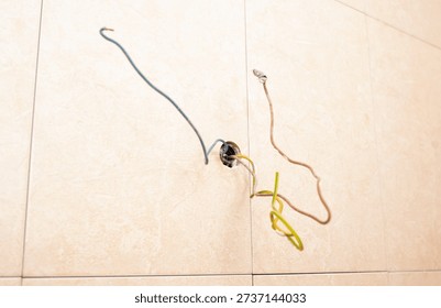 Electrical work in bathroom or kitchen showing colorful insulated wires prepared for light fixture or socket outlet installation.