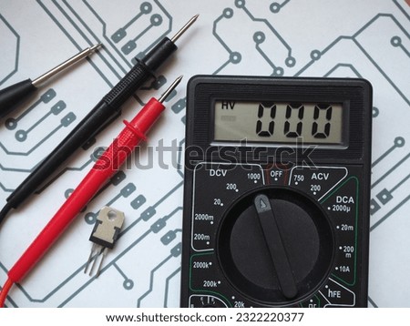 Electric-Electronic Engineering concept with drawing paper and digital multimeter.