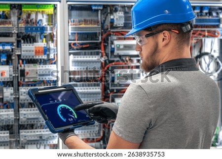 Electrician analyzing data. Tablet interface. Digital power monitoring.
