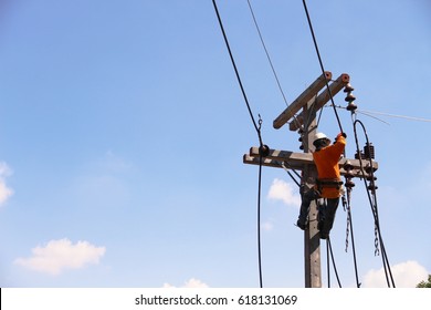 Electrician builder on electric poles. Electrical repairs are made to restore them to normal. Power line support, insulators and wires.Assembly / installation of new support and wires of a power line.