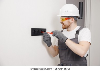 Electrician Builder Working Switches And Sockets Of Residential Electrical System, Black Color.