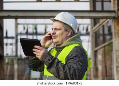 Electrician With Cell Phone In The Electric Substation