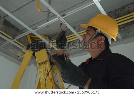 Electrician checking the current for the installation of electrical system in the house. Concept of electrical installation in the house and safety in construction.