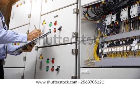 Electrician checking electric current voltage at circuit breaker terminal and cable wiring main power distribution board AHU starter control panel and Electricity or electrical maintenance service.