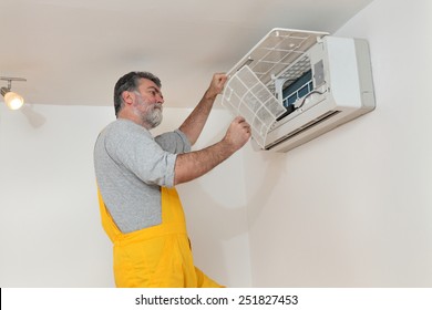 Electrician Cleaning Filter Of Air Condition Device In A Room