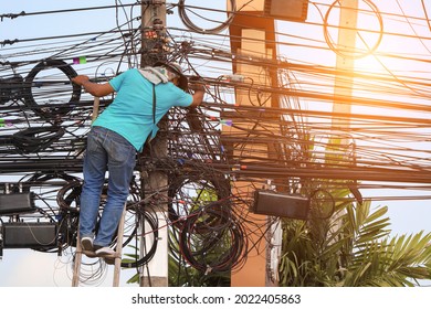 An Electrician Is Climbing An Electric Pole To Inspect And Install Wires Without Wearing Protective Equipment For Safety From Work Risks.