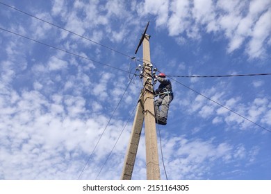 An Electrician Climbs On Poles, Repairs Power Lines. It's A Risky Job.  Selective Focus.