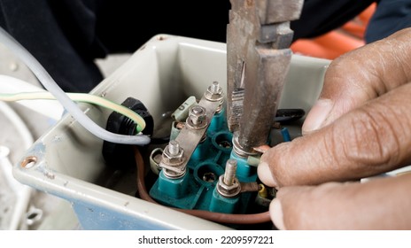 An Electrician Connecting The Cable Terminals Power Induction  Three Phase Motor.