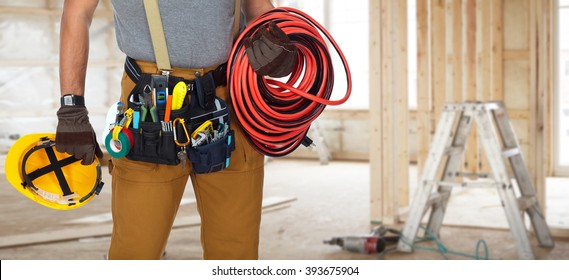 Electrician With Construction Tools And Cable.