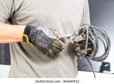 Electrician cutting and trimming cable with pliers