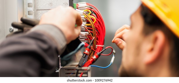 Electrician engineer tests electrical installations and wires on relay protection system. Bay control unit. Medium voltage switchgear