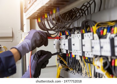 Electrician engineer tests electrical installations and wires on relay protection system. Adjustment of scheme of automation and control of electrical equipment. - Shutterstock ID 1977752018