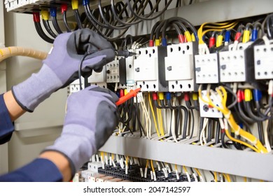 Electrician engineer tests electrical installations and wires on relay protection system. Adjustment of scheme of automation and control of electrical equipment. - Shutterstock ID 2047142597