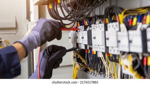 Electrician engineer tests electrical installations and wires on relay protection system. Adjustment of scheme of automation and control of electrical equipment. - Shutterstock ID 2176517883