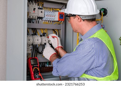 Electrician engineer tests electrical installations and wires on relay protection system. Bay control unit. Medium voltage switchgear. - Powered by Shutterstock