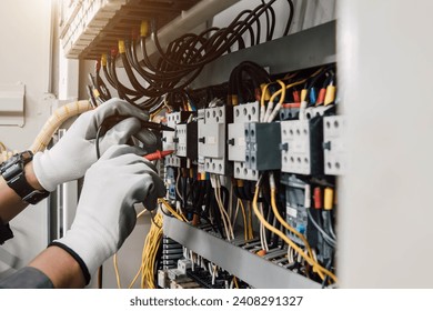 Electrician engineer tests electrical installations and wires on relay protection system.
