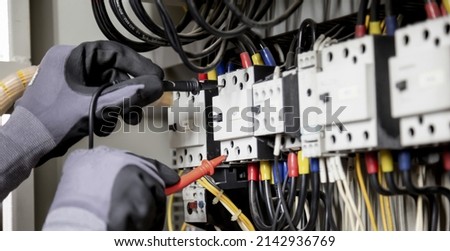 Electrician engineer tests electrical installations and wires on relay protection system. Adjustment of scheme of automation and control of electrical equipment.