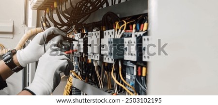 Electrician engineer tests electrical installations and wires on relay protection system.