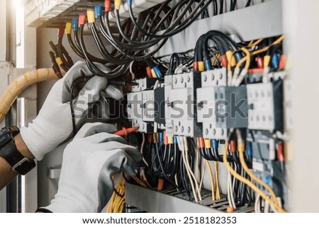 Electrician engineer tests electrical installations and wires on relay protection system.
