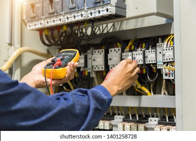 Electrician engineer work  tester measuring  voltage and current of power electric line in electical cabinet control.