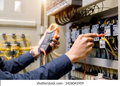 Electrician engineer work  tester measuring  voltage and current of power electric line in electical cabinet control. - Shutterstock ID 1426041959
