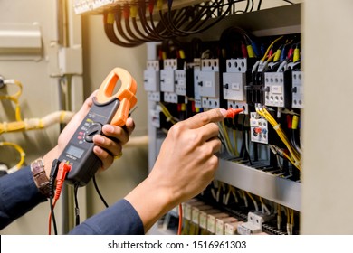 Electrician engineer work  tester measuring  voltage and current of power electric line in electical cabinet control. - Shutterstock ID 1516961303