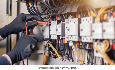 Electrician engineer work tester measuring voltage   current power electric line in electical cabinet control and wires relay protection system  Bay control unit  Medium voltage switchgear 