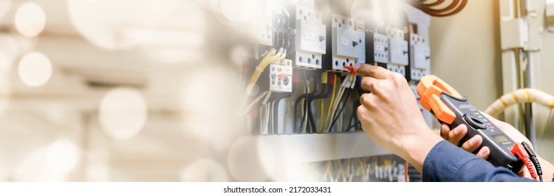 Electrician engineer work  tester measuring  voltage and current of power electric line in electrical cabinet control.