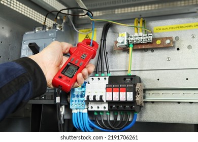 Electrician engineer work tester measuring voltage and current of power electric line in electical cabinet control.and wires on relay protection system. Bay control unit. Medium voltage switchgear.. - Shutterstock ID 2191706261