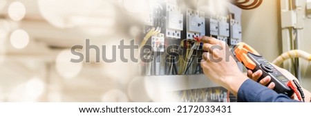 Electrician engineer work  tester measuring  voltage and current of power electric line in electrical cabinet control. Foto stock © 