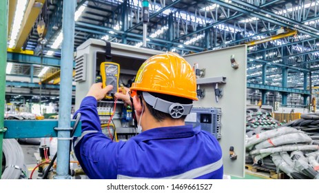 Electrician engineer works to repair a control panel at substation with voltage meter equipment in industry factory, Technician job check the fault in switch board at construction site