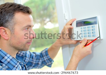 Electrician fitting an intrusion alarm