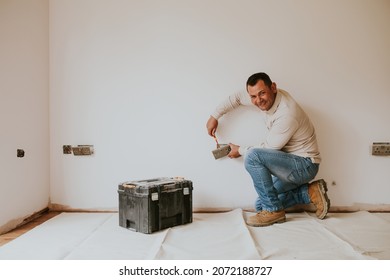 Electrician Fixing The Power Outlet On The Wall