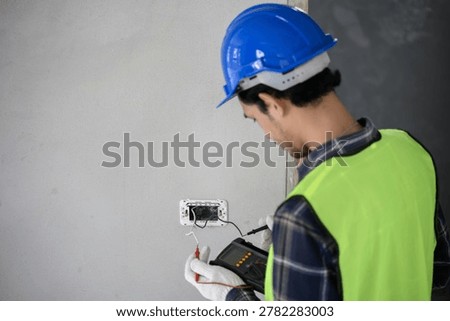 Electrician house construction worker using voltmeter check electric wire that been prepared and install before assemble light switch for safety working procedure. Industrial safety inspection concept