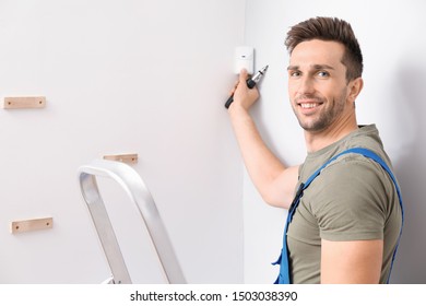 Electrician Installing Alarm System Indoors