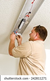 Electrician Installing Ballast In Light Fixture