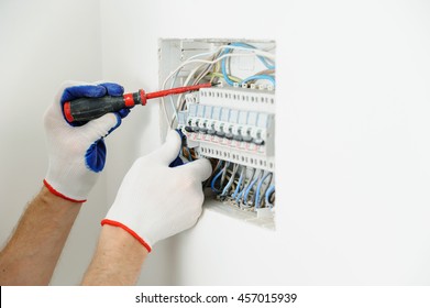 Electrician Installing An Electrical Fuse Box In A House.